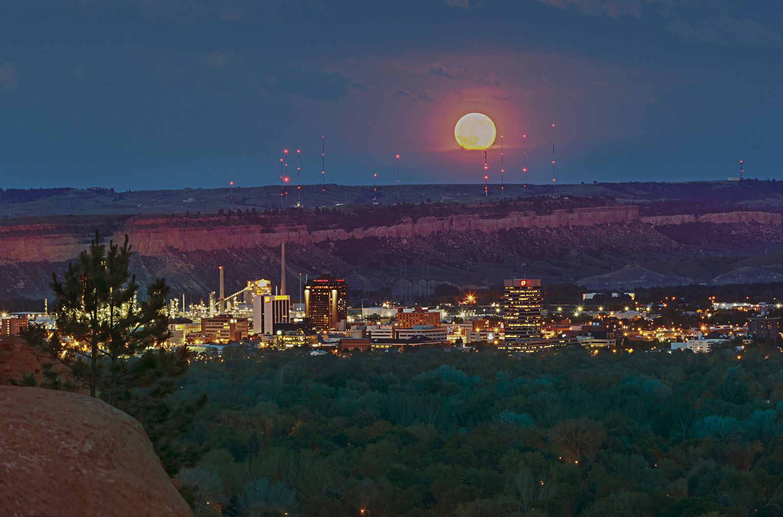 Billings, Montana city lights at dusk below the Rimrocks with a full moon rising